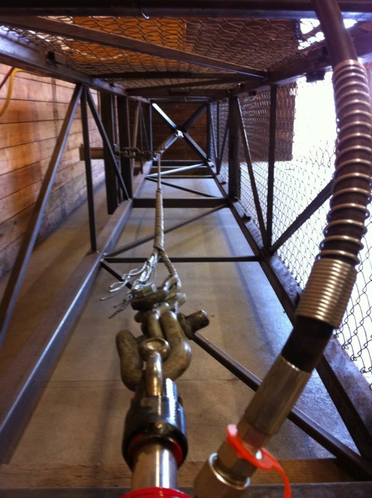 A metal cage-like structure with a chain and mechanical components inside