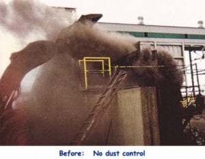A construction site with heavy machinery emits a large cloud of dust, indicating lack of dust control.