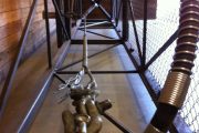 A metal cage-like structure with a chain and mechanical components inside