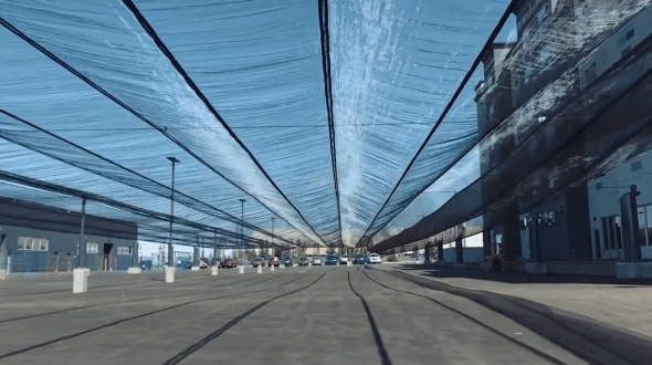 A long, covered roadway with a translucent canopy overhead and buildings on either side