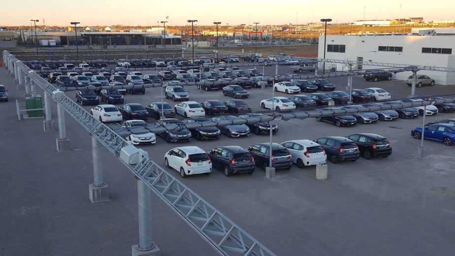 Aerial view of a car dealership lot with hail canopies retracted and wrapped up