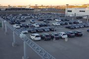 Aerial view of a car dealership lot with hail canopies retracted and wrapped up