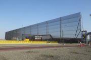 A large industrial wind fence with a clear blue sky in the background