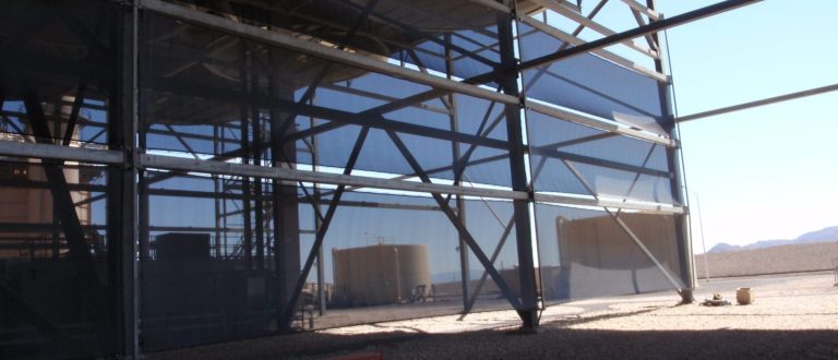 A large industrial structure with metal framework and blue mesh panels