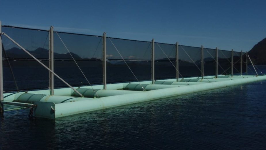 A floating structure with netting and cylindrical floats on a body of water