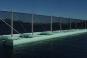 A floating structure with netting and cylindrical floats on a body of water